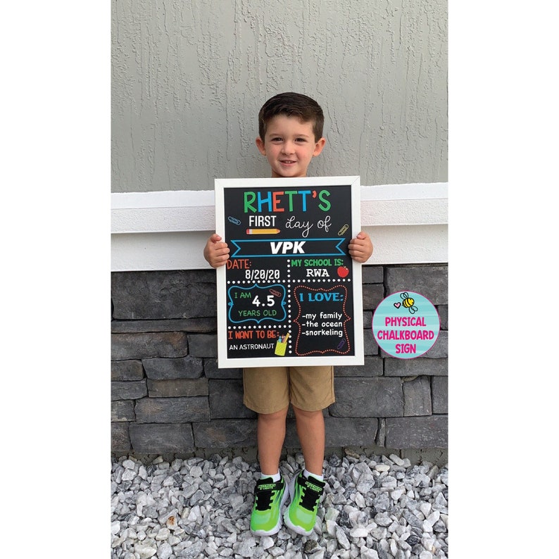 Shows child holding a milestone chalkboard sign that is reusable to document milestones for the first and last day of school.