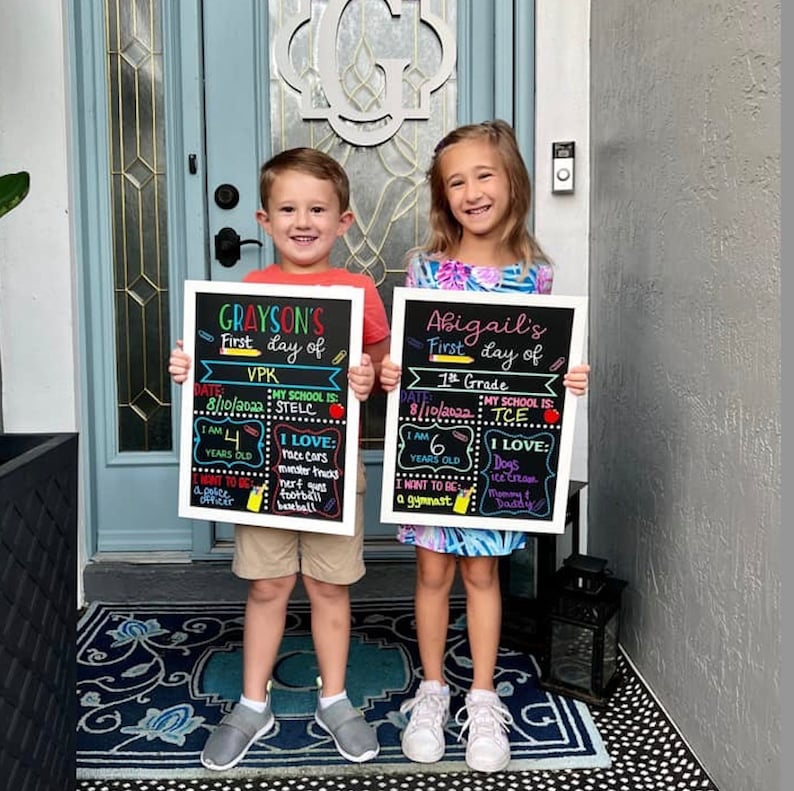 Shows children holding milestone chalkboard signs that are reusable to document milestones for the first and last day of school.