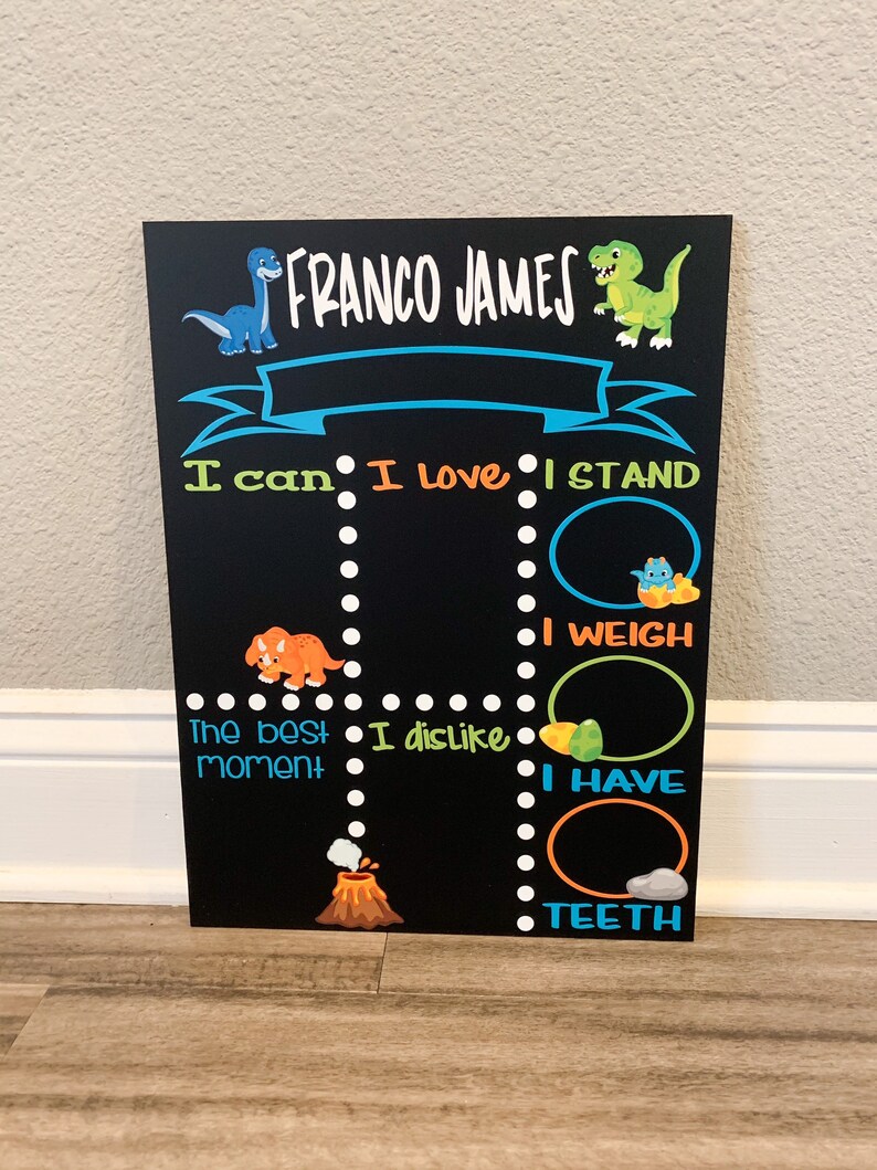 Puede incluir: Una pizarra negra con tem&aacute;tica de dinosaurios. Tiene el nombre "FRANCO JAMES" en la parte superior. La pizarra tiene secciones para "Puedo", "Me encanta", "Me pongo de pie", "El mejor momento", "No me gusta", "Peso", "Tengo" y "Dientes".
