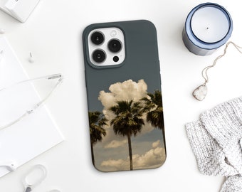 May include: A dark gray phone case with a white cloud and palm trees design. The case has a camera lens cutout and a matte finish.