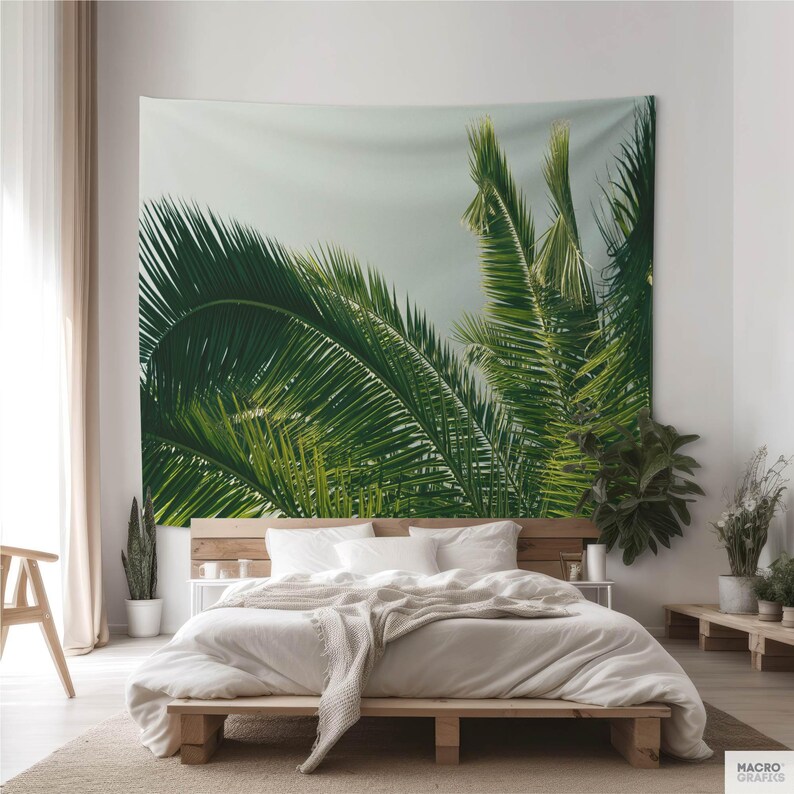 a bedroom with a large tapestry of palm leaves hanging on the wall behind a bed.