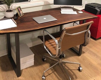 May include: A brown live edge desk with black metal legs and a brown leather office chair with silver metal arms and base. A laptop computer is on the desk.