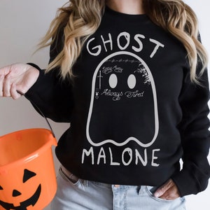 Może przedstawiać: Czarna bluza z białym nadrukiem w kształcie ducha. Duch zawiera napis "Ghost Malone" i "Always Tired". Duch ma również krzyż i symbol królika Playboya.