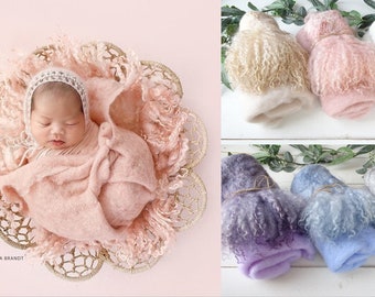 May include: A set of six fluffy newborn baby wraps in various colors, including cream, pink, white, purple, blue, and gray. The wraps are rolled up and tied with twine. The wraps are made of a soft, fuzzy material that is perfect for newborn photography.