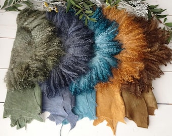 May include: Four different colored fluffy sheepskin rugs. The rugs are arranged in a row from left to right, with the green rug on the left, the blue rug in the middle, the teal rug in the middle, and the brown rug on the right.