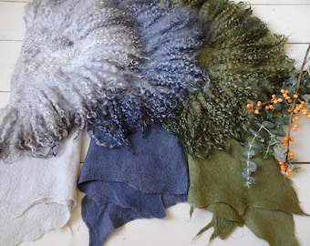 May include: Three pieces of fabric in different shades of gray, blue, and green. The fabric is fluffy and textured, resembling fur.
