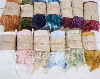 May include: A collection of 12 bundles of yarn in various colors, including orange, green, blue, purple, pink, beige, light blue, green, and yellow. Each bundle is wrapped in brown paper and tied with twine. The yarn is fluffy and textured.