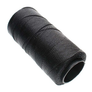 May include: A black nylon thread spool, tightly wound with a textured surface. The thread is wrapped around a cylindrical core. Suitable for various crafting and repair tasks. The spool is compact and durable.