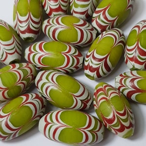 May include: A collection of green, white and red oval-shaped beads with a marbled swirl pattern.