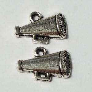 Op de afbeelding: Twee zilverkleurige metalen megafoonbedels met een lus om aan een ketting of armband te bevestigen.