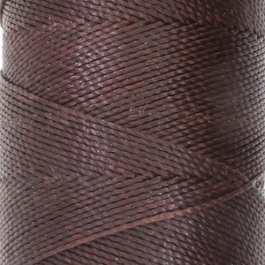 May include: A spool of brown waxed thread.