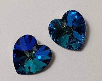 May include: Two blue heart-shaped crystal charms with a hole for stringing. The crystals have a faceted design and a teal-blue color.