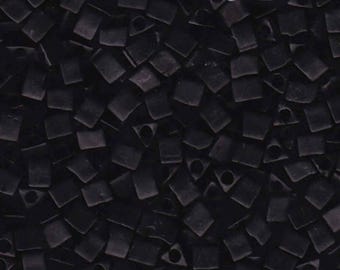 May include: A close-up shot of numerous small, black, square beads. Each bead features a hole, forming a geometric design. The beads are densely packed, filling the entire image frame.