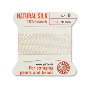 May include: A spool of natural silk thread, labeled "NATURAL SILK" and "No. 6". The thread is a creamy white color, with a diameter of 0.70 mm. The packaging includes the text "For stringing pearls and beads" and the brand logo.