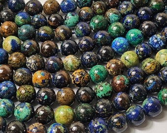 May include: A strand of round, blue, green, and brown gemstone beads. The beads are all approximately the same size and have a mottled, irregular surface.