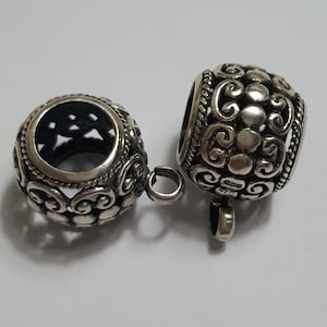 Può includere: Due tappi per perline in metallo argentato con intricati motivi floreali e un anello su ciascun lato. I tappi per perline sono progettati per essere utilizzati come tappi finali per collane o braccialetti.