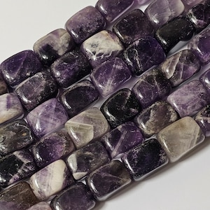 May include: A strand of purple and white amethyst gemstone beads. The beads are rectangular and have a smooth, polished finish.
