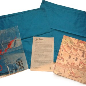 May include: Teal-colored pillowcases with a matching package and a printed card. The package is clear with red text and a logo. The card has printed text. A decorative card with a detailed illustration is also included.