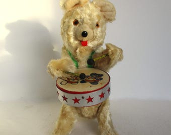 Oso de juguete antiguo de cuerda que toca la batería y baila en el circo.