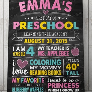 May include: A black chalkboard sign with colorful text announcing a child's first day of preschool. The sign says "Emma's First Day of Preschool" and includes details like the child's age, teacher's name, and favorite things.
