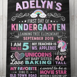 May include: A chalkboard-style sign with the text "Adelyn's First Day of Kindergarten." It features a rainbow, stars, and a unicorn graphic. The sign also includes the text "I am 5 years old" and "I stand 46 inches tall."