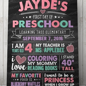May include: A black chalkboard sign with colorful text announcing the first day of preschool for Jayde. It includes details like her age, teacher's name, favorite activities, and future aspirations. The sign is decorated with hearts, stars, and a red apple.