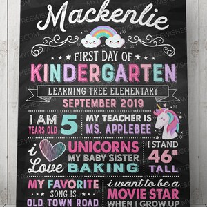 May include: A chalkboard-style sign for a child's first day of kindergarten. The sign includes the child's name, "First Day of Kindergarten," and other details like age, teacher's name, and height (46 inches). It features a rainbow, unicorn, and decorative elements.