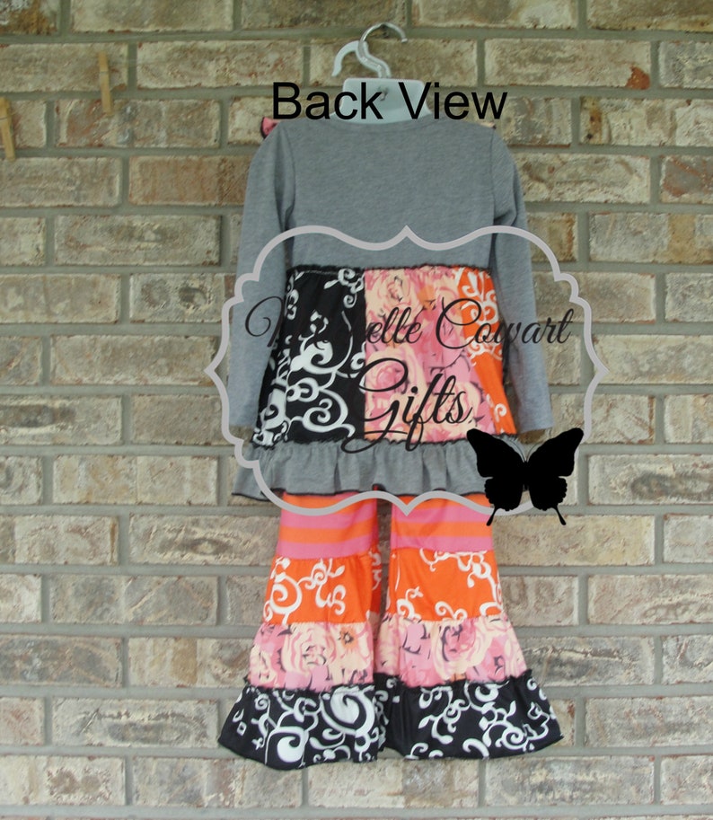 May include: A gray long-sleeve top and patterned pants set. The pants feature orange, pink, and black floral and swirl designs. The text "Back View" is visible above the outfit.