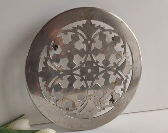 Pierced work French vintage trivet, 9" / 23 cm diameter, on 4 moving wheels / castors, table decor, circa 1920s.