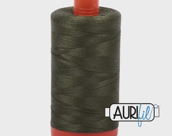 Könnte beinhalten: Eine Spule dunkelolivgrünes Garn mit roter Basis und Oberseite. Der Faden ist fest gewickelt und die Spule hat das Aurifil-Logo auf der Seite. Ideal für Näh- und Quiltprojekte.