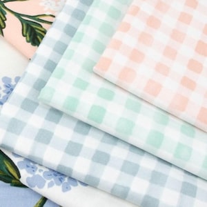 May include: A stack of pastel-colored fabric squares with a gingham pattern. The colors include light blue, mint green, and peach. Floral patterns are visible on the edges of some of the fabric.