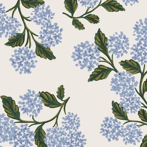 May include: A repeating pattern of blue hydrangea flowers and green leaves on a cream backdrop. The floral design has a hand-painted style, highlighting the natural shapes and colours of the flowers and foliage.