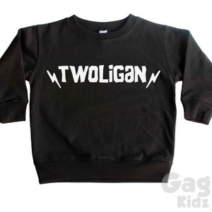 May include: Black long-sleeved sweatshirt with white lightning bolts and the text "TWOLIGAN" printed on the front.