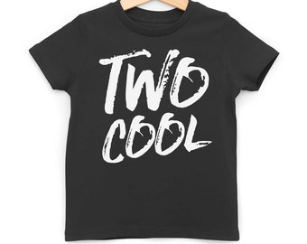 May include: Black t-shirt with white text that says "TWO COOL" in a brushstroke font. The shirt is hanging on a wooden hanger.