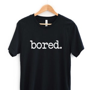 May include: Black t-shirt with white text that reads "bored."