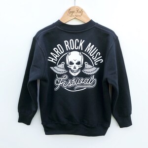 May include: Black sweatshirt with a white graphic print of a skull with wings and the text "Hard Rock Music Festival".