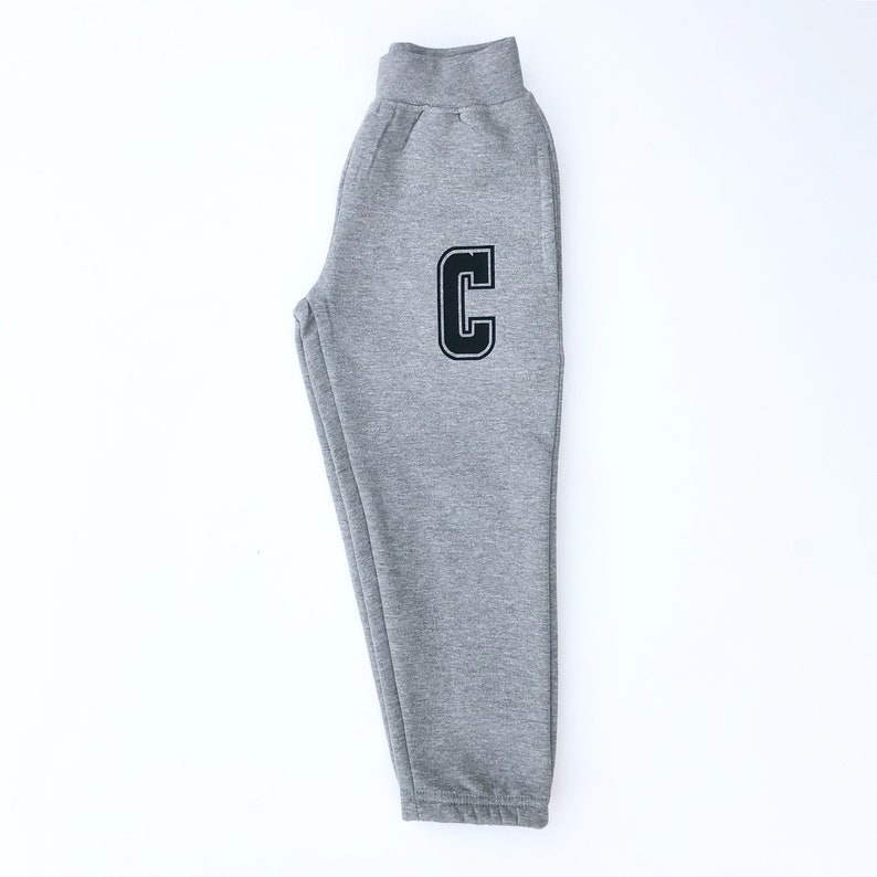 May include: Gray sweatpants with a black letter C on the left leg.