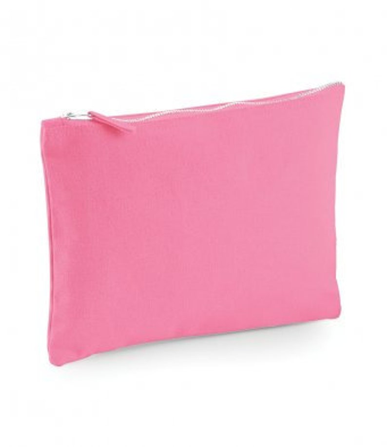 May include: A pink canvas zippered pouch. The pouch is made of a soft, textured fabric and has a zipper closure.