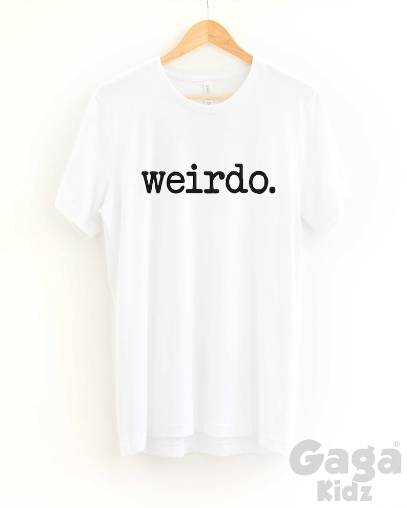 May include: White t-shirt with black text that reads "weirdo."