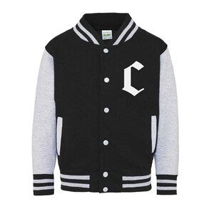 Op de afbeelding: Zwart en grijs varsity jack met witte strepen aan de randen en een witte letter "C" op de voorkant.