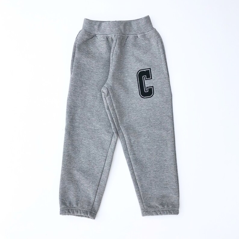 May include: Grey sweatpants with a black letter C on the right leg.