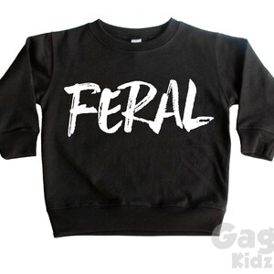 May include: Black long-sleeve sweatshirt with the word "FERAL" printed in white on the front.