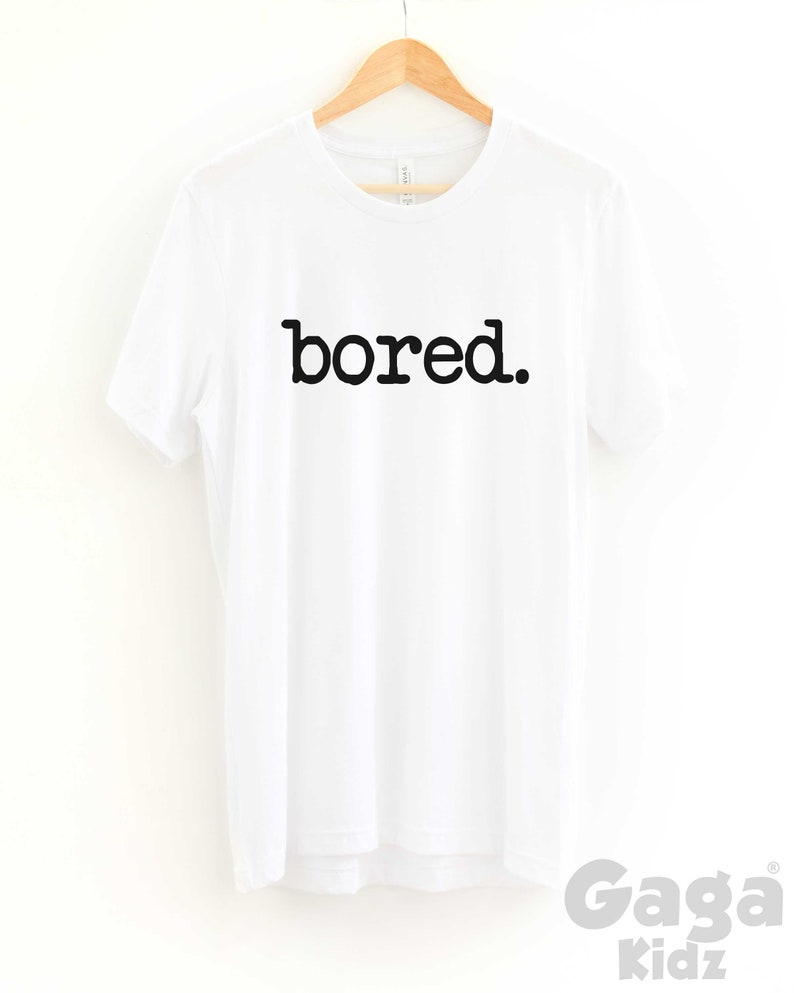 May include: White t-shirt with black text that reads "bored."