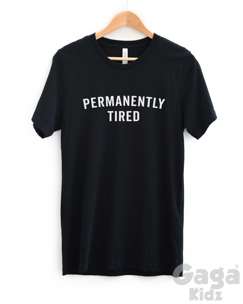 Puede incluir: Camiseta negra con texto blanco que dice "PERMANENTLY TIRED".