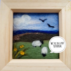 Op de afbeelding: Een ingelijst naaldviltwerk dat een landschap voorstelt met een blauwe lucht, witte wolken, een groen veld, bruine heuvels en drie witte schapen. De tekst "We're in a PDF Tutorial" staat in een spreekballon in de rechterbenedenhoek van de afbeelding.