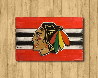May include: A wooden sign with a red, white, and black striped background. A stylized image of a Native American head with a feather headdress is in the center of the sign.