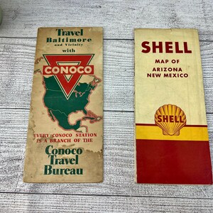 May include: Two vintage travel brochures. One is for Conoco Travel Bureau, featuring a map of the United States. The other is a Shell map of Arizona and New Mexico. Both are rectangular and show signs of age.