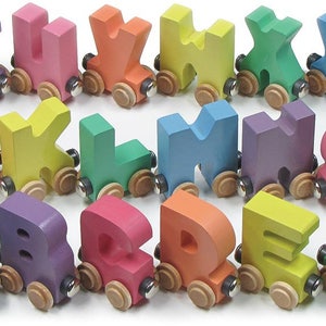 K&ouml;nnte beinhalten: Ein Set aus bunten Holzz&uuml;gen in Form von Buchstaben des Alphabets. Jeder Zug hat eine andere Farbe und einen anderen Buchstaben und sie sind alle in alphabetischer Reihenfolge angeordnet. Die Z&uuml;ge sind aus Holz und haben eine glatte, lackierte Oberfl&auml;che.