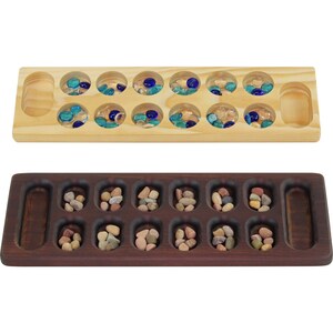 May include: Two wooden game boards for playing Mancala. The top board is light wood with clear glass marbles. The bottom board is dark wood with small brown stones.