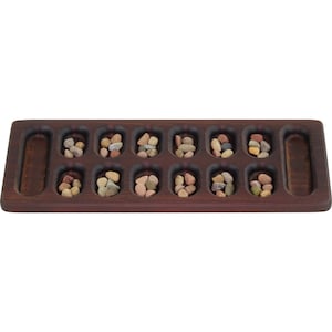 May include: A wooden game board with 12 small depressions, each filled with colorful stones. The board has two larger depressions on either end.